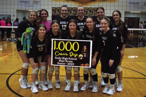 Sealy’s volleyball team surrounds Blair Kram, center with sign, as she celebrated recording 1,000 career digs against Wharton last Tuesday. The Lady Tigers are playing inspired volleyball as they have reached the 30-win plateau for the season. PHOTO BY ABENEZER YONAS