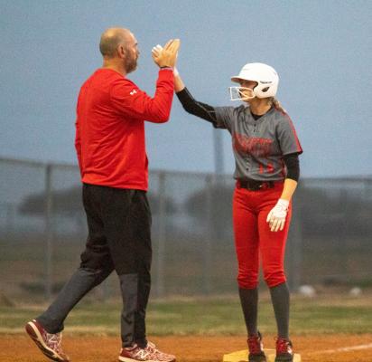 Cougarette junior Taylor Brzozowski high-fives Brazos Head Coach Dustin Nilius after a stand-up triple against Royal Feb. 22 in Wallis. COLE McNANNA