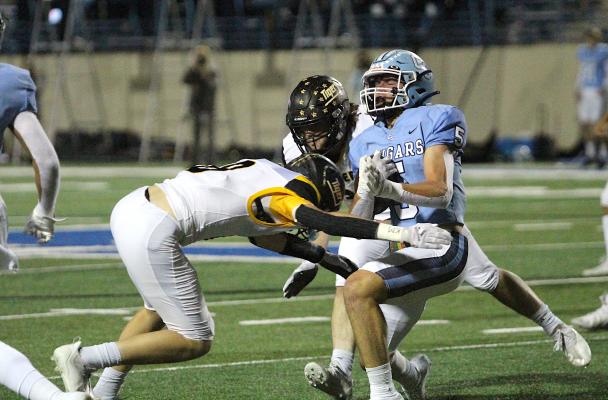 Tiger sophomore Reid Miller delivers a blow to China Spring's Tristan Exline following the Cougars' interception in the first half of Friday's second-round playoff game in Waco. COLE McNANNA