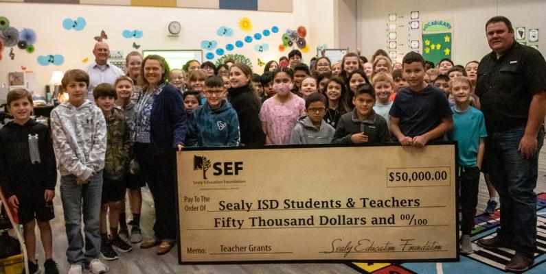 Holly Svec, holding check at left, and her music students at Sealy Elementary School were visited by the Sealy Education Foundation who awarded a $750 grant for a traveling sound system last Thursday, March 24. COLE MCNANNA