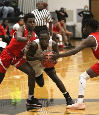Sealy junior A’vonte Nunn drives the lane through El Campo defenders during the Tigers’ district-opening game at home last Friday. COLE MCNANNA
