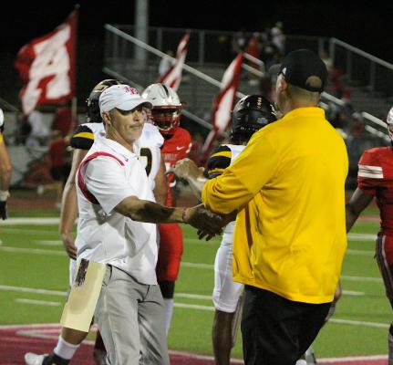 Head Coaches Grady Rowe and Shane Mobley meet after the 83rd Battle of Mill Creek Friday night at the Pasture of Pain. Bellville’s 42-7 win extends its all-time lead in the series to 49-34. COLE McNANNA