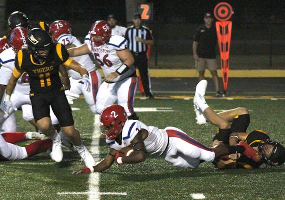Sealy’s Jeffrey Neu secures a tackle of Brazosport’s Paul Woodard at the line of scrimmage in the first half of the Tigers’ regular-season opener against the Exporters at T.J. Mills Stadium Friday. COLE McNANNA