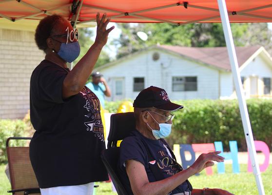 Finus O. Tyler and his wife Evelyn wave to paradegoers who drove by the Tyler’s house Sunday afternoon in honor of Finus’ 100th birthday April 11. (Cole McNanna/Sealy News)