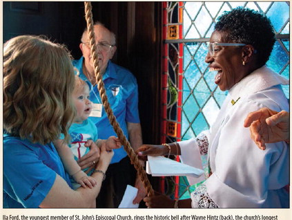 Ila Ford, the youngest member of St. John’s Episcopal Church, rings the historic bell after Wayne Hintz (back), the church’s longest serving parishioner, as part of the bell tower’s rededication ceremony, Saturday, Aug. 1, in Sealy. Ford is held by her mother Ellie Ford and helped by Rev. Rhonda Fanning. PHOTOS BY THE SEALY NEWS | ALLISON DRINNON