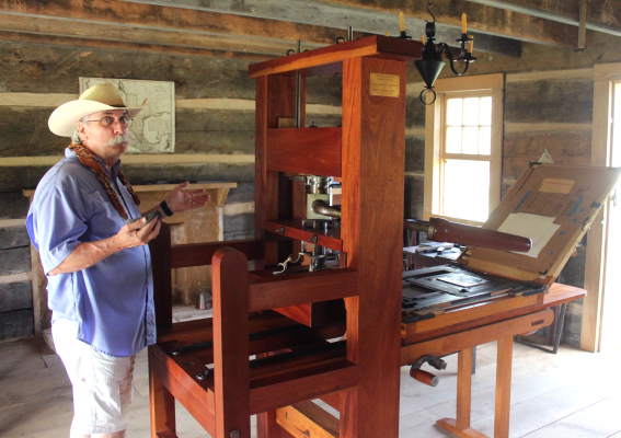 San Felipe de Austin State Historic Site volunteer Mark Keith appreciates the recently donated printing press in its new home at the log cabin Texas Gazette printing office in the Villa de Austin. HANS LAMMEMAN