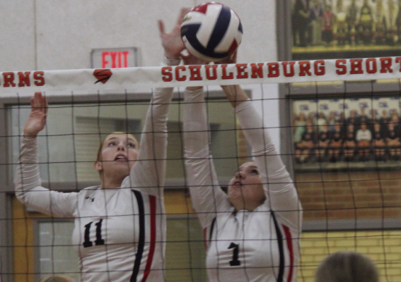 Bayleigh Marek (left) and Rylea Roecker combine to block a ball at the net.