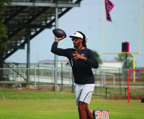 Head Coach Patrick Oliver throws a ball to one of his receivers during a drill. SEALY NEWS | EVAN HALE