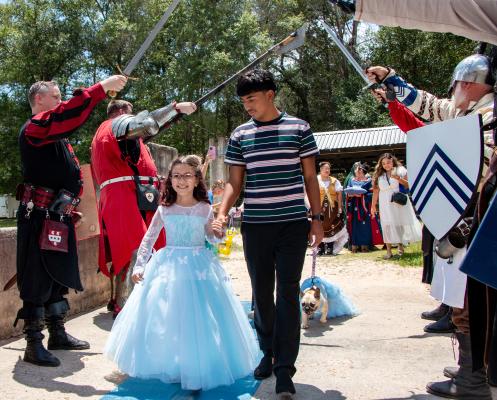 Chris Flores walks his sister Audriana Ashinhurst down a sparkly blue carpet into Newman's Castle for her royal celebration hosted by Make-A-Wish, Sunday, Aug. 3, in Bellville.