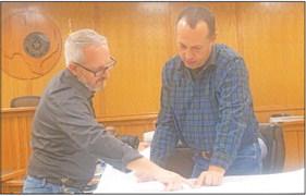 Austin County Judge Tim Lapham and County EMS Chief Walter Morrow look over the drawings for the three new EMS buildings being constructed in Bellville, Wallis and Industry. PHOTO BY JIMMY GALVAN