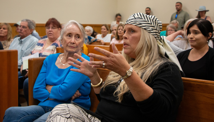     Bridget Kourik (right) questions CleanSpark representatives during public comment for a moratorium on data centers during Austin County Commissioners Court, Monday, July 27, in Bellville. 