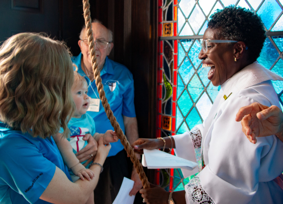 Ila Ford, the youngest member of St. John’s Episcopal Church, rings the historic bell after Wayne Hintz (back), the church’s longest serving parishioner, as part of the bell tower’s rededication ceremony, Saturday, Aug. 1, in Sealy. Ford is held by her mother Ellie Ford and helped by Rev. Rhonda Fanning. PHOTOS BY THE SEALY NEWS | ALLISON DRINNON