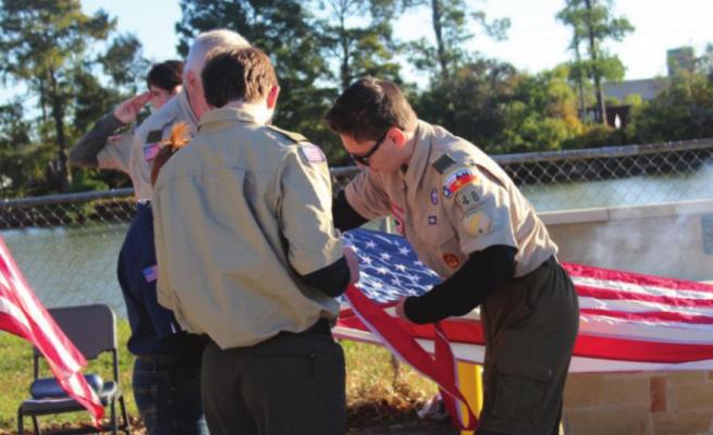 Tyler Burgess carefully cut each stripe from the American flag during the Flag Retirement Ceremony. HANS LAMMEMAN