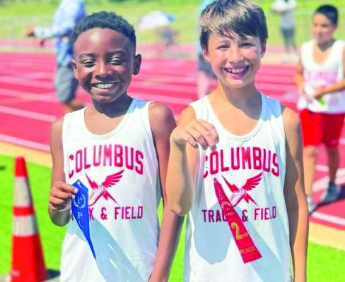 Dallas Taylor (left) and Jude Heffley show off the ribbons they won with the Columbus Youth Track team.