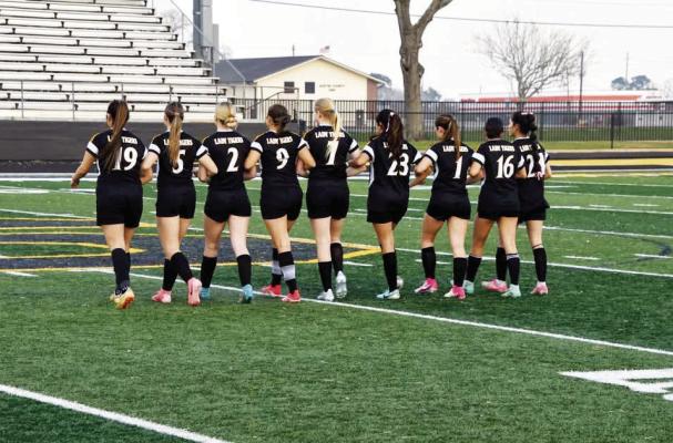 Sealy Lady Tigers’ seniors, Maritza Navarro (left), Alana Lindsay, Jessica DeBerry, Lani Krenek, Elizabeth Reichart, Alexandra Vazquez, Avery Schalla, Emily Magana and Dominique Castillo, walk arm-in-arm together to the captain’s meeting. COURTESY PHOTO