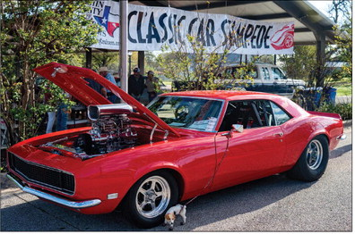 An old red Chevrolet Camaro sits with an open engine space at the Austin County Classic Car Stampede, Saturday, March 14, in Bellville.