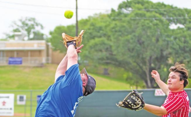 Austin County Sheriff’s Deputy Danny Duron leaps for a catch during the exhibition softball game between law enforcement officers and fire/EMS personnel at the Bellville Little League Fields Saturday, April 16. The Police team won 16-4. COLE McNANNA