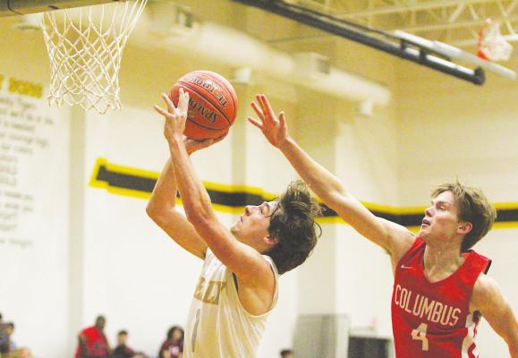 Sealy junior Ryder Ramirez flies to the basket and avoids contact from Columbus’ Trace Brandon during the first half of the non-district game between the Tigers and Cardinals at Sealy High School last Tuesday. COLE McNANNA