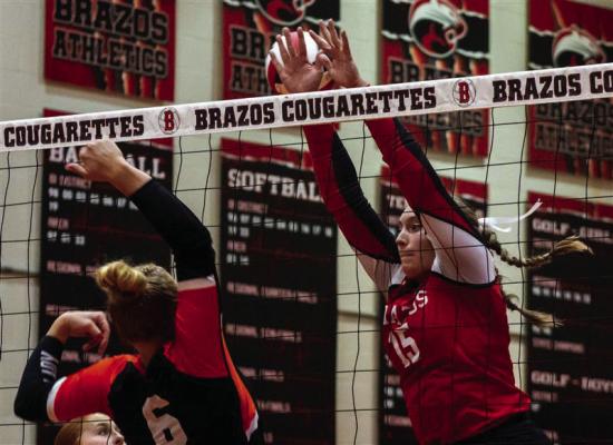 McKenna Stroud leaping up to block the ball at the net for the Cougarettes. SEALY NEWS | ALLISON DRINNON