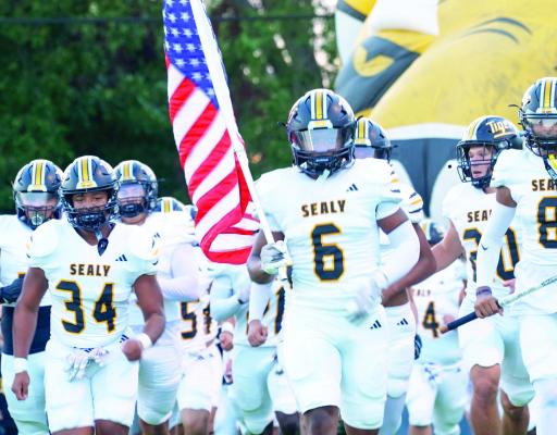 Sealy junior Javien Grant trots out with the American flag as the Sealy Tigers take the field during last Friday’s matchup with Cameron Yoe. Sealy defeated Cameron Yoe 48-13 to move to 2-0 on the season. Sealy’s defense and special teams keyed a strong first half for the Tigers. Photo courtesy Brackston Nutt