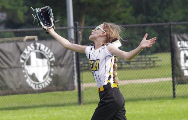 Jordan Pomikal extends her arm trying to catch a pop fly in the outfield.