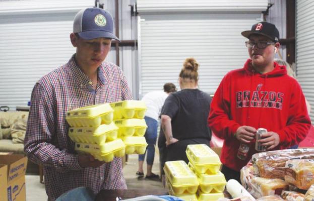 Christopher and Dayton Prado gather food to distribute into boxes for recipients Wednesday, Nov. 24.