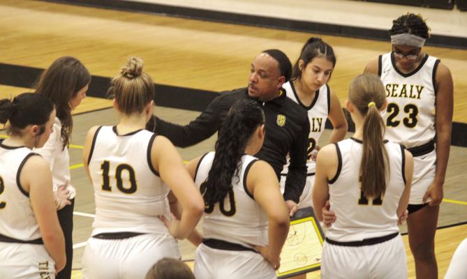 The Sealy Lady Tigers head coach Ray Dabney draws up a play during a timeout.