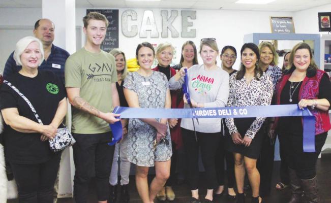 Rebecca Clanton-Lewis, Season 7 Episode 2 Cupcake Wars winner, readies to cut the ribbon at the Dec. 14 ceremony for Birdies Deli &amp; Co. in Bellville. She was joined by deli staff, members from the Bellville Chamber of Commerce and staff from Blinn College Small Business Development Center. HANS LAMMEMAN