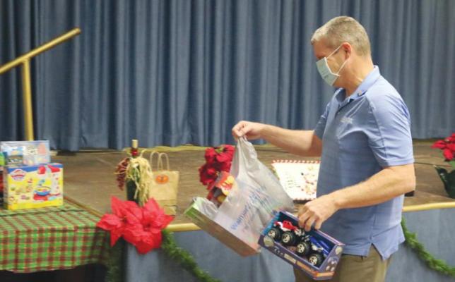 Russ Rainwater drops off unwrapped toys for the Sealy Police Department’s Blue Santa program during the annual holiday mixer hosted by the Sealy Chamber of Commerce Thursday at the American Legion hall.