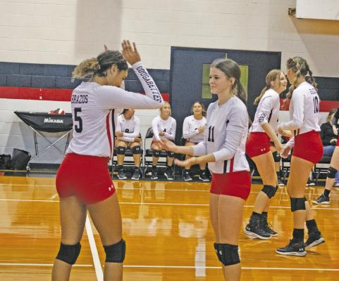 JASON MANAGO-GRAVES Brazos seniors Haiven Alvarado-Harris and Jemma Zahradnik high-five each other during their matchup against Ganado High School on Aug. 16 at the Brazos High School gymnasium.