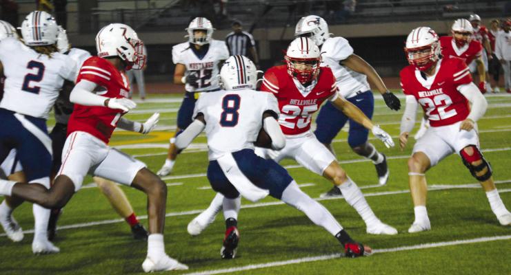 Bellville’s Cayden Becerra (22) and Connor Gaines (25) close in on a Madisonville runner during last Friday’s win.
