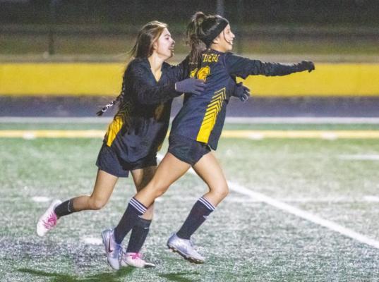 Sealy freshman Dominique Castillo (24) and Alexia Murillo (16) celebrate Murillo’s goal in the second half of the Lady Tigers’ District 20-4A contest against Discovery last Friday at T.J. Mills Stadium. COLE McNANNA
