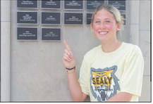 Ryanne Meyer points at her newly unveiled plaque on the Sealy Wall of Champions on Thursday, Aug. 6, at Sealy High School. SEALY NEWS | EVAN HALE