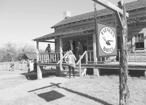 Guests gathered on the porch of the Farmer’s Hotel and tavern during the Grand Opening of the Villa de Austin at the San Felipe de Austin State Historic Site Friday, Nov. 12. HANS LAMMEMAN