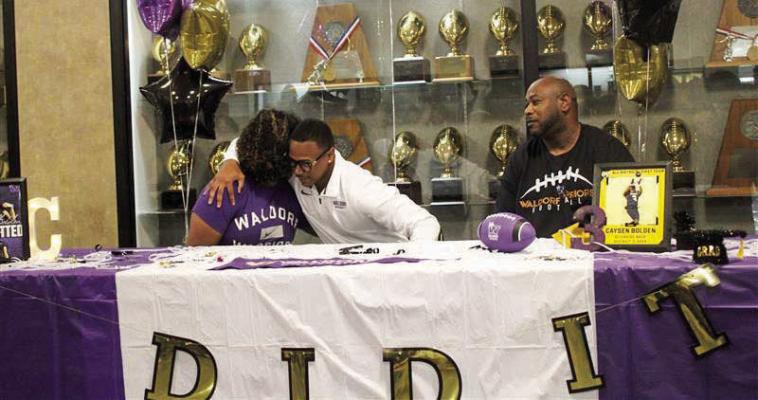 Caysen Bolden signs to commit to Waldorf University with his mother Cassie Morris (left) and his father Jason Bolden (right) by his side. SEALY NEWS | EVAN HALE
