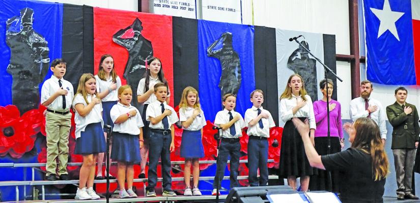 Sophomore Georgia Johnson with elementary students singing the Star Spangled Banner. CONTRIBUTED PHOTO