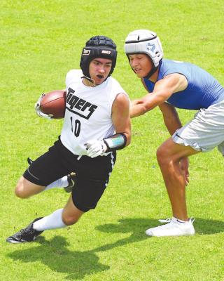 Tiger receiver Bradley Garbs puts a spin move on a Taylor defender during Sealy’s first contest in the 7-on-7 league at James E. Taylor High School June 9.