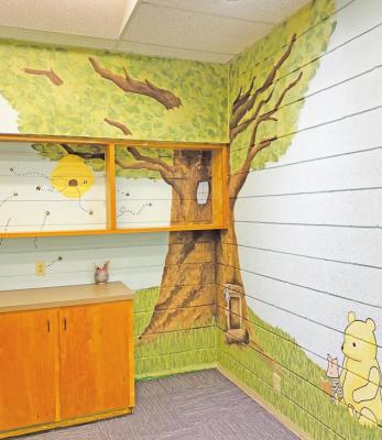 ABOVE: Hannah Moyle has decorated the new toddler room at the Virgil &amp; Josephine Gordon Memorial Library with a Winnie the Pooh mural as part of the facility’s many upgrades.