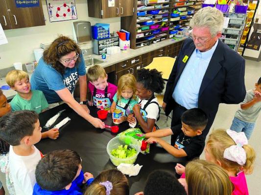 Andrea Ford and Dr. Kenneth Stein assist young people during their garden kitchen day. COURTESY PHOTO