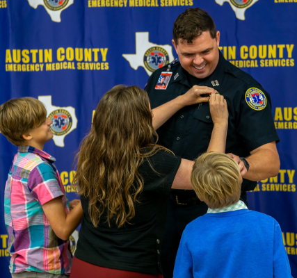 Daniel Owens is pinned as Clinical Chief of Austin County EMS by children.