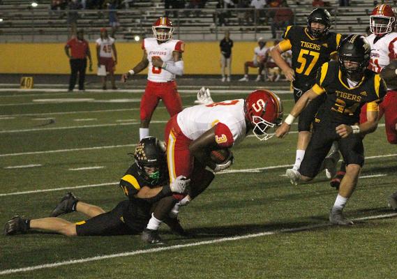 Tiger junior Haden Wernecke hangs on for a tackle of Stafford running back Tyler Miller during Sealy's non-district battle at T.J. Mills Stadium Friday. COLE McNANNA