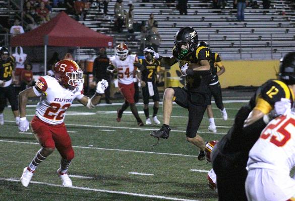 Sealy junior Haden Wernecke hurdles over Stafford defenders during the Tigers' Homecoming matchup with the Spartans Friday at T.J. Mills Stadium. COLE McNANNA