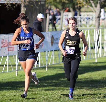 Sealy freshman Blair Konesheck battles Needville's Nataly Flores near the finish line of the state championship meet at Old Settlers Park in Round Rock Saturday morning. COLE McNANNA