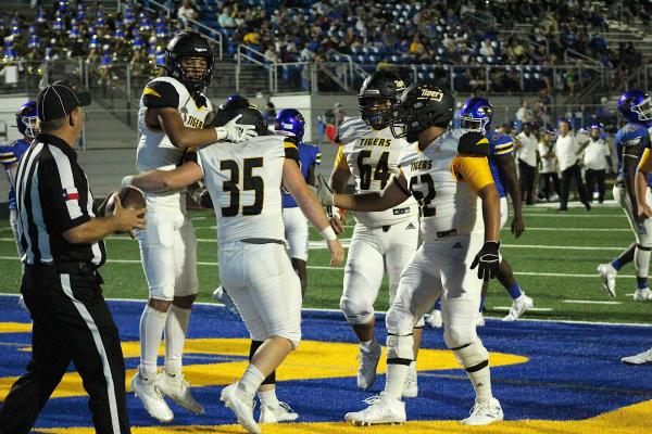 Sealy senior Ethan Hart is swarmed by teammates after his first touchdown Friday night in Bay City. COLE McNANNA