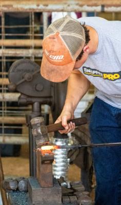 Russell Feller strikes the iron while it’s hot during the Texas Select Custom Cutlery event last weekend at the Austin County Fair Convention and Expo Center. COLE McNANNA
