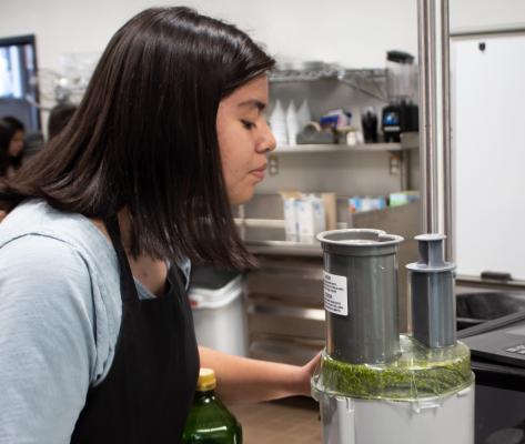 Sealy High School senior Mariana Ponce inspects the pesto sauce during class in the culinary kitchen April 14. COLE McNANNA