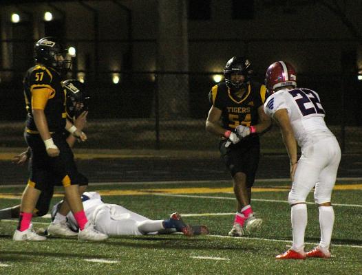 Sealy senior Jonathan Monterroza (54) celebrates a tackle for a loss during the Tigers’ 26-0, district-opening win over Royal Friday night at T.J. Mills Stadium. He and Rylan Reichardt (57) both contributed three tackles on the night. COLE McNANNA