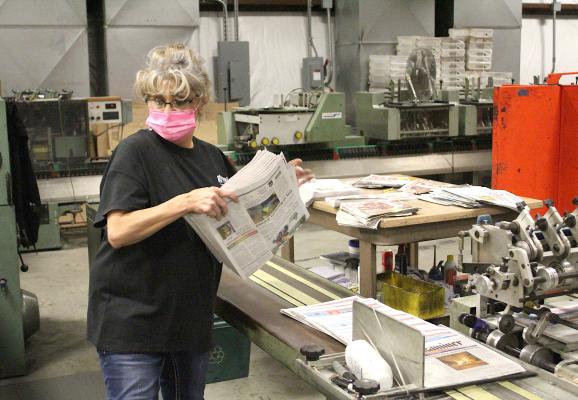Director of Print Operations Ory Boney prepares a bundle of papers to be wrapped at the Granite Printing Press in Taylor Feb. 18. (Cole McNanna/Sealy News)