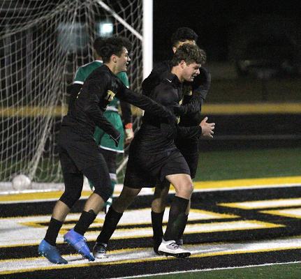 Sealy junior William Forrester is swarmed by classmates Rodolfo Olivarez and Amador Lopez after the defender scored the Tigers’ second goal of the first half in their district-opening game against Hempstead last Friday at T.J. Mills Stadium in Sealy. COLE McNANNA