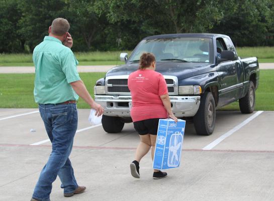 Sealy Parks Director Lawrence Siska and Combined Community Action Executive Secretary Dalila Mansiya handout heat-preventative items Monday outside LeBlanc Pool. COLE McNANNA
